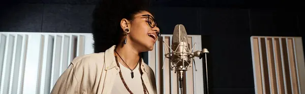 Une femme chante passionnément dans un micro, déversant son cœur et son âme dans la musique lors d'une répétition d'un groupe de musique dans un studio d'enregistrement. — Photo de stock