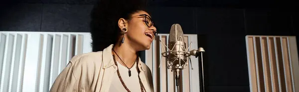 Una donna canta appassionatamente in un microfono, versando il suo cuore e la sua anima nella musica durante le prove di una band musicale in uno studio di registrazione. — Foto stock