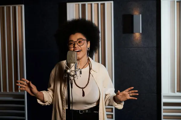 Una mujer talentosa vierte su alma en un micrófono, creando música en un estudio de grabación durante un ensayo de la banda. - foto de stock