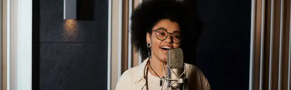 Una donna canta appassionatamente in un microfono in uno studio di registrazione professionale durante le prove di una band musicale. — Foto stock