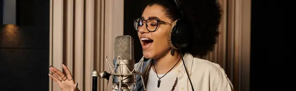 Una donna canta appassionatamente in un microfono in uno studio di registrazione durante le prove di una band musicale. — Foto stock
