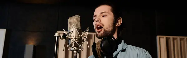 A talented man passionately sings into a microphone, pouring his heart out in a recording studio during a music band rehearsal. — Foto stock