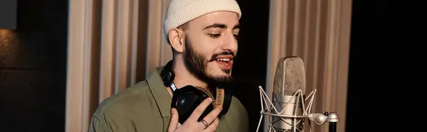 Un uomo con la barba canta appassionatamente in un microfono durante le prove di una banda musicale in uno studio di registrazione. — Foto stock