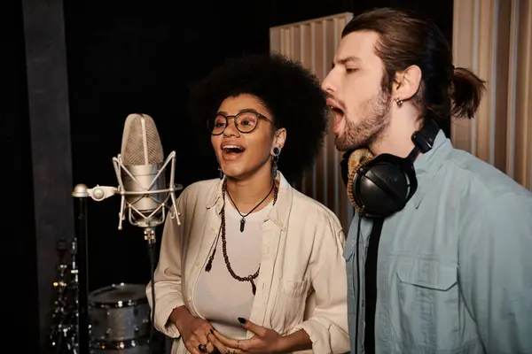 A man and woman passionately sing into microphones in a recording studio, surrounded by musical instruments. — Stock Photo