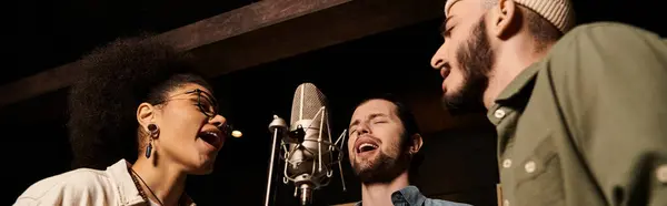 Una variegata band musicale che prova insieme in uno studio di registrazione, cantando appassionatamente in un microfono. — Foto stock