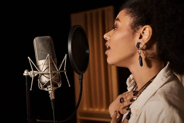 Una donna di talento canta appassionatamente in un microfono mentre registra in uno studio musicale con la sua band. — Foto stock