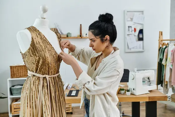 Young woman in casual attire upcycling clothes, sewing a dress on a mannequin. — Stock Photo