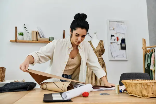 A young woman in casual attire upcycling her clothes, working on a project. — Stock Photo