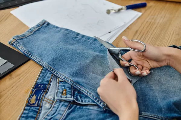 A person reinvents old jeans with scissors. — Stock Photo