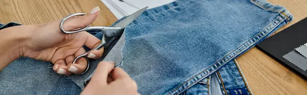 Persona upcycling jeans con tijeras. - foto de stock