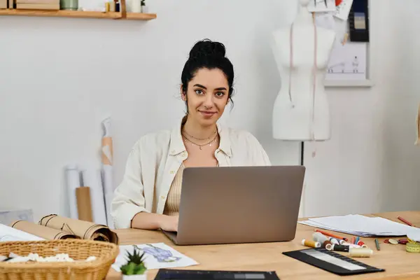 Donna in abbigliamento casual upcycling vestiti di fronte al computer portatile. — Foto stock