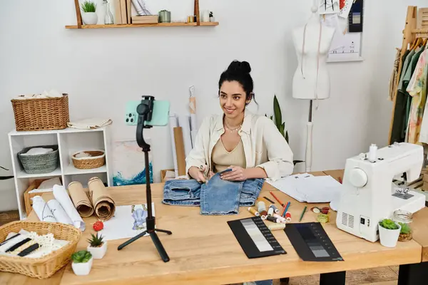 Una mujer bordadores en una máquina de coser en un viaje creativo, upcycling ropa. - foto de stock