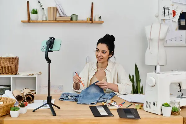 A young woman in casual attire upcycling her clothes at a sewing machine. — Stock Photo
