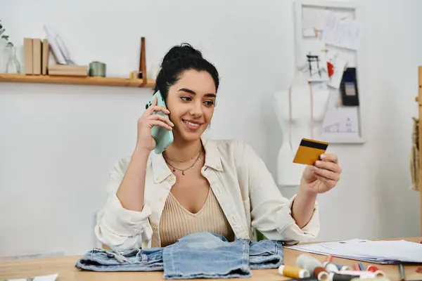 Young woman multitasking with phone and credit card. — Stock Photo