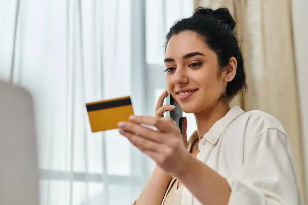 Una donna multitasking con una carta di credito e un cellulare. — Foto stock