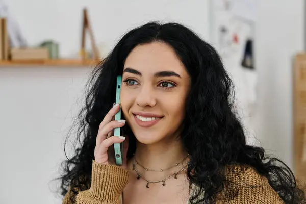 A woman chatting on phone while upcycling clothes for eco-friendly fashion. — Stock Photo