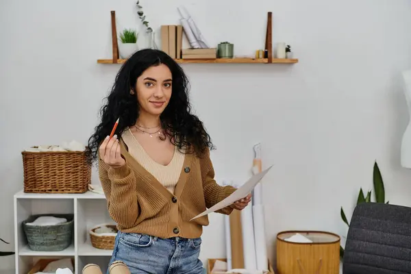 Woman in casual attire upcycling clothes holding pen and paper. — Stock Photo