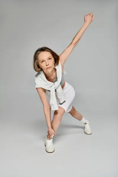 Зріла жінка демонструє витонченість у білій спідниці та взутті. — стокове фото