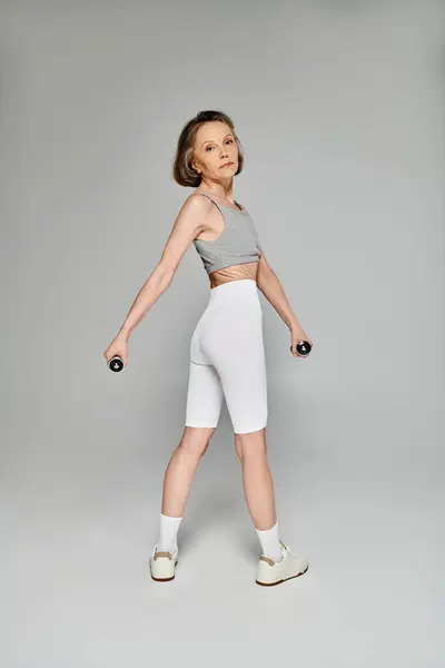 Active woman showcasing strength with dumbbells. — Stock Photo