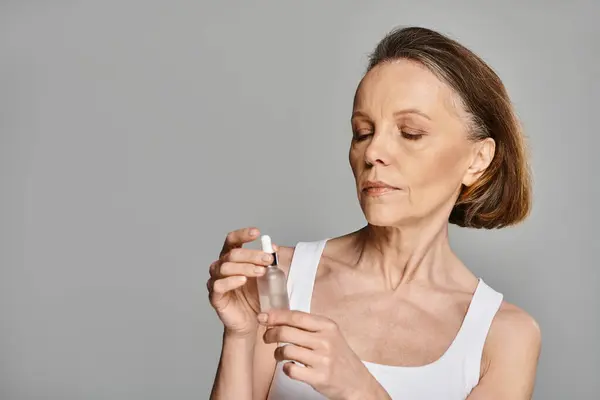 Woman elegantly holding a serum bottle. — Stock Photo