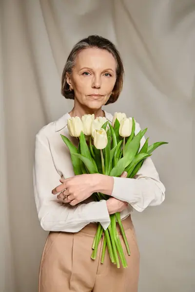 A woman gracefully holds a vibrant bouquet of tulips. — Stock Photo