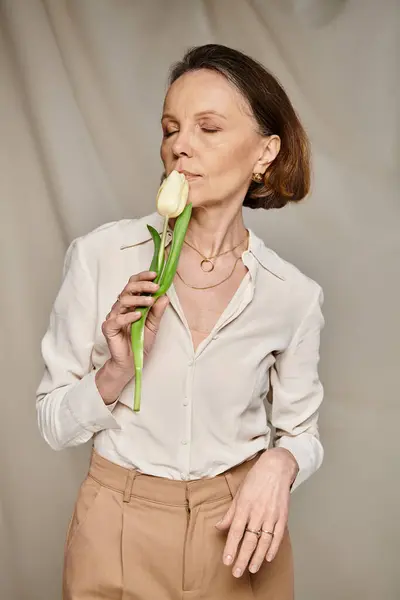 Eine Frau hält anmutig eine Tulpe in der Hand. — Stockfoto