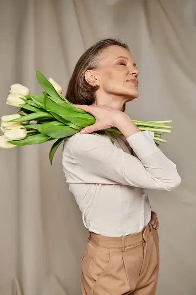 Woman gracefully holding a bouquet of vibrant tulips. — Stock Photo