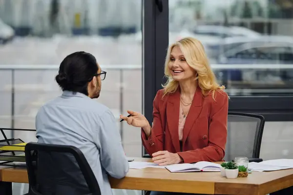 Eine Frau und ein Mann diskutieren an einem Bürotisch über Geschäfte. — Stockfoto