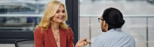 A woman engages in conversation with a man in the office setting. — Stock Photo