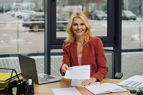 A woman immersed in work at a cluttered desk with papers. — Stock Photo