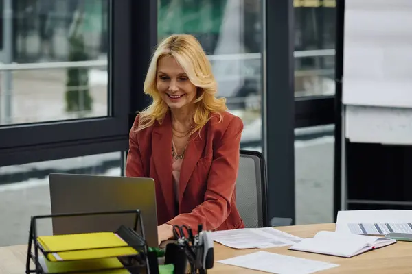 A woman works on a laptop at a desk. — Stock Photo