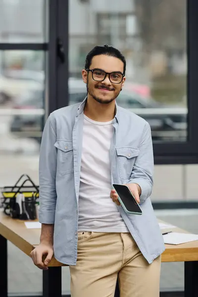 Jovem usando telefone celular na frente da mesa. — Fotografia de Stock