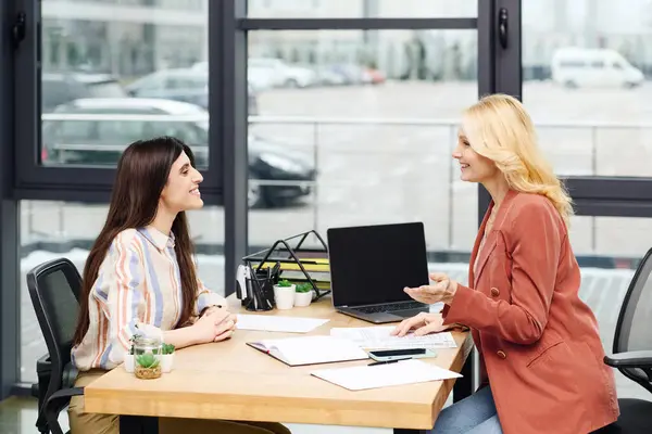 Две целеустремленные женщины беседуют за современным столом офиса. — стоковое фото