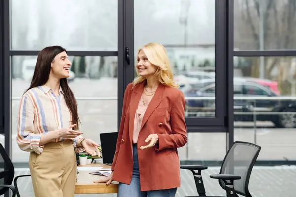 Two professional women engaged in a conversation at the office. — Stock Photo