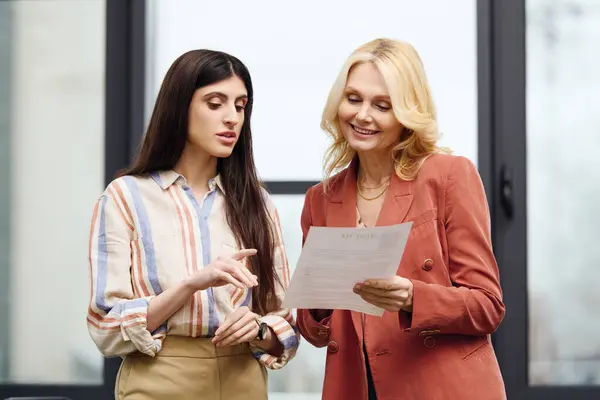 Deux femmes engagées dans une conversation dans un bureau occupé. — Photo de stock