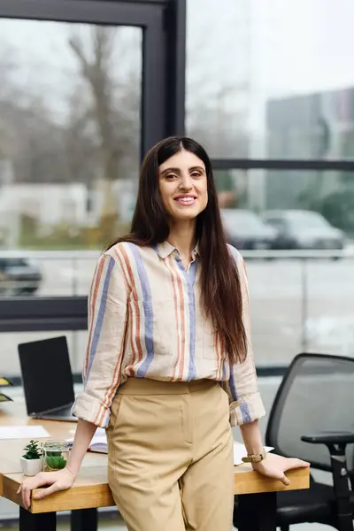 Eine Frau steht vor einem Bürofenster und überlegt vor einem Vorstellungsgespräch. — Stockfoto