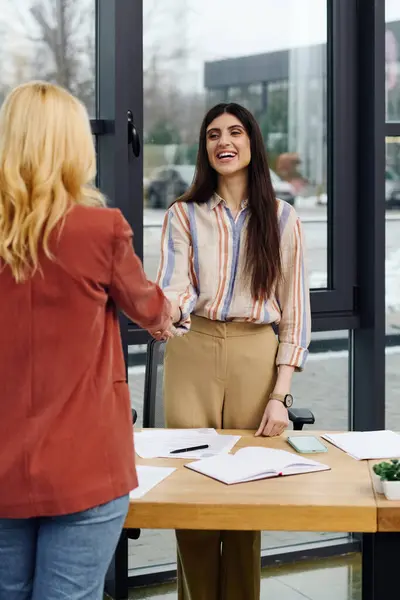 Duas mulheres fechando um negócio com um aperto de mão em um ambiente de escritório. — Fotografia de Stock