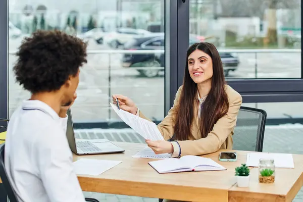 Uomo e donna si impegnano in una conversazione alla scrivania durante il colloquio di lavoro. — Foto stock