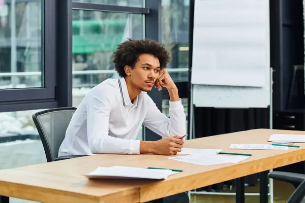Un uomo concentrato mentre si siede ad una scrivania. — Foto stock