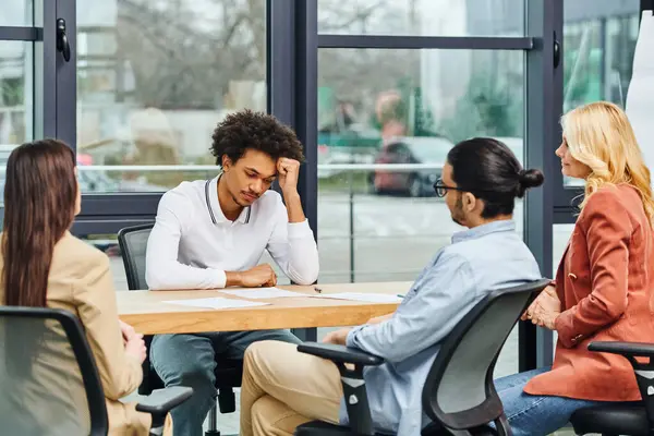 Un grupo diverso de profesionales discutiendo un proyecto alrededor de una mesa de conferencias. - foto de stock