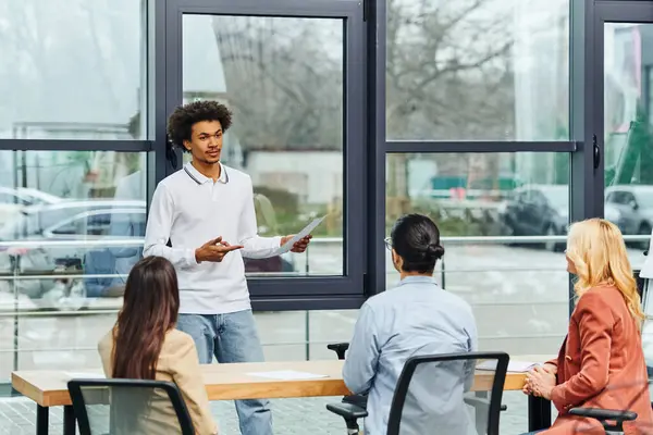 A man presenting to a group of people in an office setting. — Stock Photo