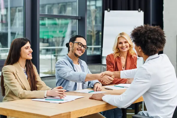 A group of job seekers shaking hands at a table during a successful networking session. — Stock Photo