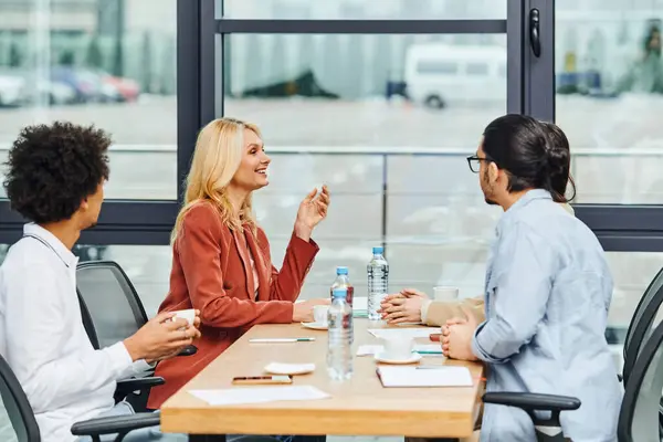 Grupo de profissionais discutindo ideias em torno de uma mesa em um ambiente de escritório contemporâneo. — Fotografia de Stock