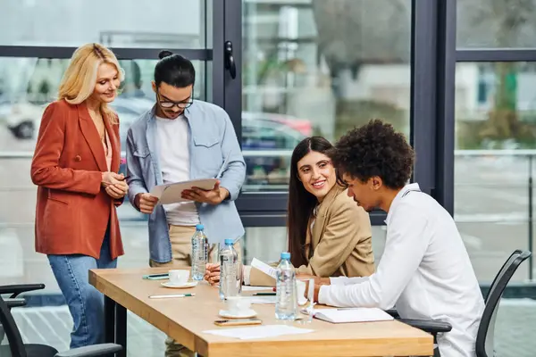 Buscadores de empleo que participan en una discusión de grupo durante una entrevista de trabajo en una mesa de oficina. - foto de stock