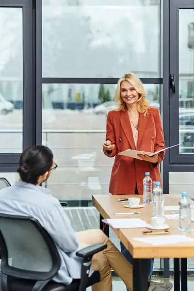 Donna professionale che offre una presentazione accattivante a un gruppo attento. — Foto stock