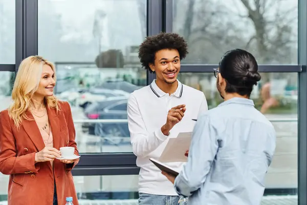 Un grupo de buscadores de trabajo que trabajan duro hablando delante de una ventana. - foto de stock