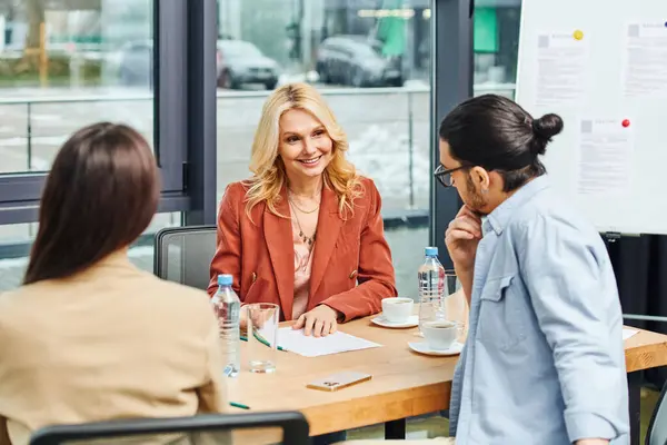 Grupo de solicitantes de empleo que participan en una entrevista de trabajo en una mesa de conferencias. - foto de stock