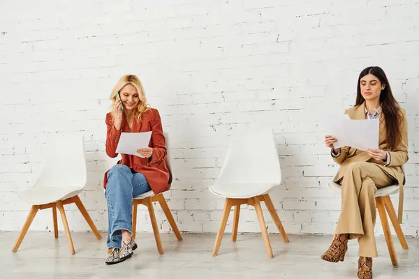 Grupo de mujeres en sillas, en espera de una entrevista de trabajo. - foto de stock