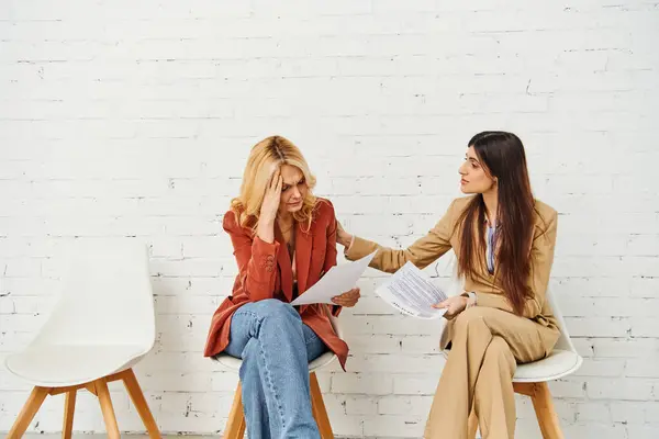 Due donne impegnate in una conversazione profonda sedute su sedie. — Foto stock