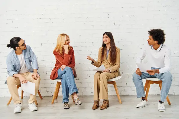 Grupo diverso que se envolve em uma discussão vibrante enquanto está sentado em cadeiras. — Fotografia de Stock